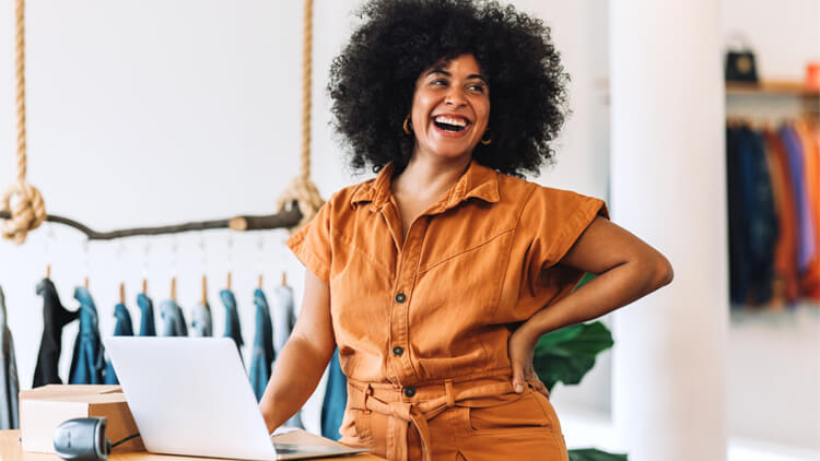 Female business woman laughing in front of her laptop